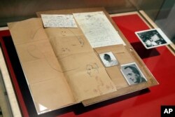 The 1960 forensic crime lab file comparing photos of Adolf Eichmann in World War II and as Ricardo Klement in Argentina are displayed in the "Operation Finale: The Capture & Trial of Adolf Eichmann" exhibit at the Museum of Jewish Heritage in New York, July 14, 2017.
