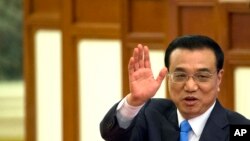 FILE - Chinese Premier Li Keqiang waves as he leaves after a press conference at the end of the National People's Congress in Beijing's Great Hall of the People.