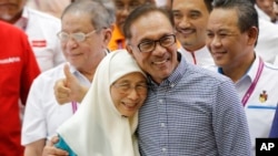 Politisi Malaysia Anwar Ibrahim (kanan) merayakan kemenangan pemilu parlemen di Port Dickson, kota di pesisir selatan Malaysia, Sabtu, 13 Oktober 2018. (Foto:AP)
