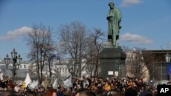 Orang-orang berkumpul di luar monumen Alexander Pushkin di tengah kota Moskow, 26 Maret 2017.