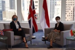 Menteri Luar Negeri Indonesia Retno Marsudi (kanan) berpose bersama Menteri Luar Negeri Inggris Elizabeth Truss setelah melakukan pertemuan di sela Sidang Majelis Umum PBB yang ke-76 di New York, Amerika Serikat, pada 20 September 2021. (Foto: Kementerian