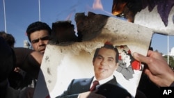  In this January 24, 2011 picture, protestors burn a photo of former Tunisian President Zine El Abidine Ben Ali during a demonstration against holdovers from Ben Ali's regime in the interim government in Tunis, Tunisia. 