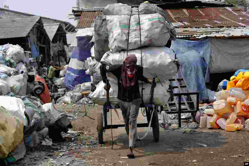 A worker pulls the cart containing plastics to be recycled at a collection point in Jakarta, Indonesia.