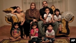 Egyptian father Youssef Shaman Gumaa, center right, and his wife Sarah Hassan Shehata, pose for a photograph with their 4 year-old quintuplets and their 7 year-old sister, top left, at their home during the holy month of Ramadan, in Madinet el-Salam on the outskirts of Cairo, Egypt, May 31, 2017.