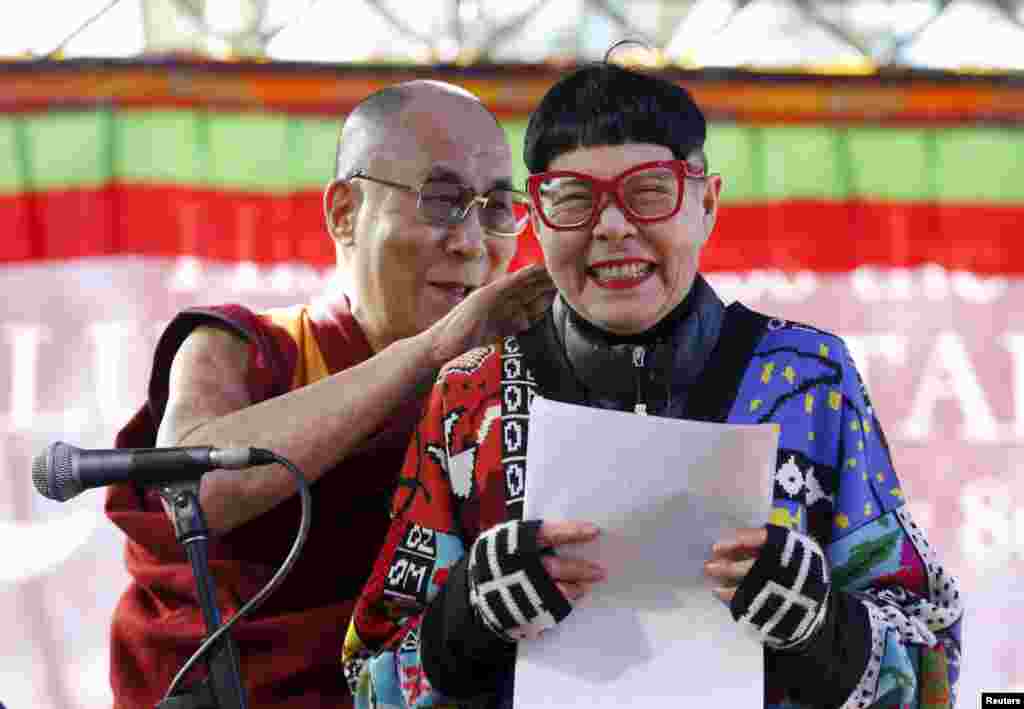 호주 시드니를 방문한 티베트의 정신적 지도자 달라이 라마가 자신을 환영하는 행사의 진행자 뒤에서 장난스러운 행동을 하고 있다.