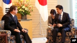 In this file photo, Japanese Prime Minister Shinzo Abe, right, speaks to South Korea's National Intelligence Service Chief Suh Hoon, left, during a meeting in Tokyo Tuesday, March 13, 2018. (Kim Kyung-Hoon/Pool Photo via AP)