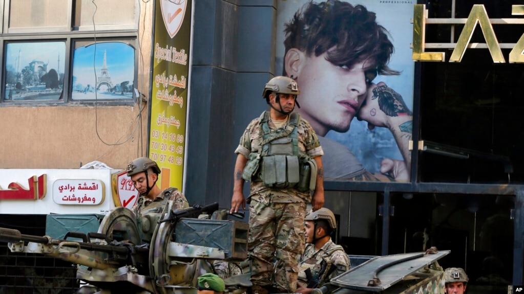 FILE - Lebanese army soldiers on their armored vehicle stand guard in Beirut, Oct. 15, 2021, at the site where deadly clashes erupted the previous day.