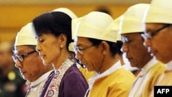 Burma's opposition leader Aung San Suu Kyi (2nd L) along with other elected members of parliament reads her parliamentary oath at the lower house of parliament during a session in Naypyidaw, May 2, 2012.