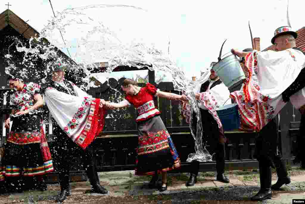 បុរសៗជះទឹកដាក់នារីៗអំឡុងពេលអបអរពិធីបុណ្យ Easter នៅក្រុង Mezokovesd ប្រទេសហុងគ្រី។ 