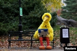 FILE - A man dressed as the "Sesame Street" character Big Bird sits on a bench in New York's Central Park, Nov. 14, 2016. In the localized versions of "Sesame Street" to be shown to kids caught up in the Syrian civil war, the characters will have regional names and speak Arabic and Kurdish.