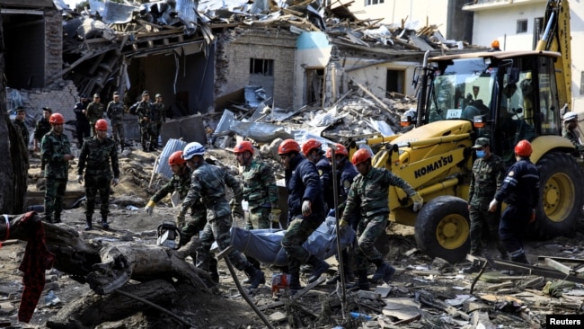 搜救人員將炮擊遇難者遺體抬出廢墟。亞塞拜然10月11日稱，亞美尼亞軍隊對占賈發動夜間炮擊。（照片來自路透社 REUTERS/Umit Bektas）
