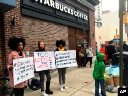 Protesters gather outside a Starbucks in Philadelphia, April 15, 2018, where two black men were arrested Thursday after Starbucks employees called police to say the men were trespassing. (AP Photo/Ron Todt)
