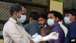 Người Ấn Độ mang khẩu trang ngừa virus Nipah đứng bên ngoài bệnh viện Trường Y của Chính phủ tại Kozhikode, bang Kerala, ngày 21/5/2018.