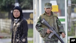 A Thai soldier looks on as a Muslim woman crosses the street in Bacho, a city in southern Thailand, where a violent insurgency in the Muslim-dominated region has been simmering since 2004. (File)