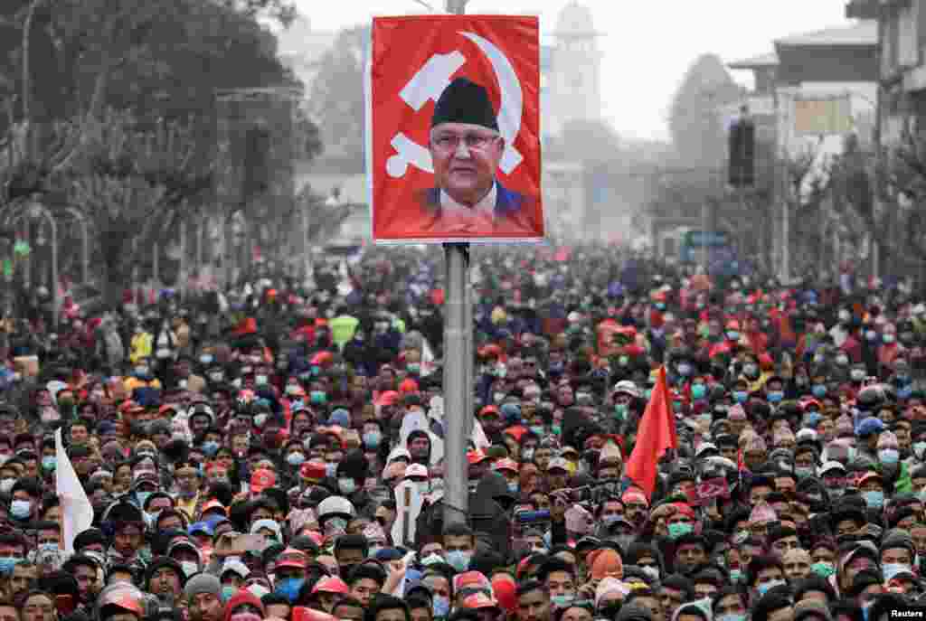 Pro-government activists gather near the portrait of Nepal&#39;s Prime Minister Khadga Prasad Sharma Oli, also known as K.P. Oli, during a mass gathering in his support, after the dissolution of parliament, in Kathmandu, Nepal.