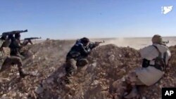 FILE - This frame grab from a video provided by the Syria Democratic Forces (SDF), shows fighters from the SDF opening fire on an Islamic State group's position, in Raqqa's eastern countryside, Syria, March 6, 2017.