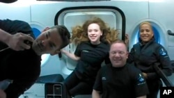 This photo provided by SpaceX shows the passengers of Inspiration4 in the Dragon capsule on their first day in space. They are, from left, Jared Isaacman, Hayley Arceneaux, Chris Sembroski and Sian Proctor. 