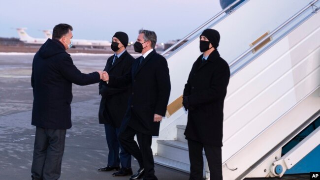 Secretary of State Antony Blinken, second from right, is greeted by Ukrainian Deputy Foreign Minister Dmytro Senik, left, as he arrives at the Boryspil International Airport, Jan. 19, 2022, in Kyiv, Ukraine.