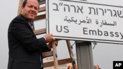 In this photo released by the Jerusalem Municipality, Jerusalem mayor Nir Barkat poses with a new road sign to the new U.S. Embassy in Jerusalem, Israel, May 7, 2018.