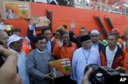 Myanmar Social Welfare Minister Win Myat Aye, second from left, receives aid from Malaysian officials after a Malaysian ship full of aid for the Muslim Rohingya minority arrived at Thilawa port in Yangon, Myanmar, Feb. 9, 2017.