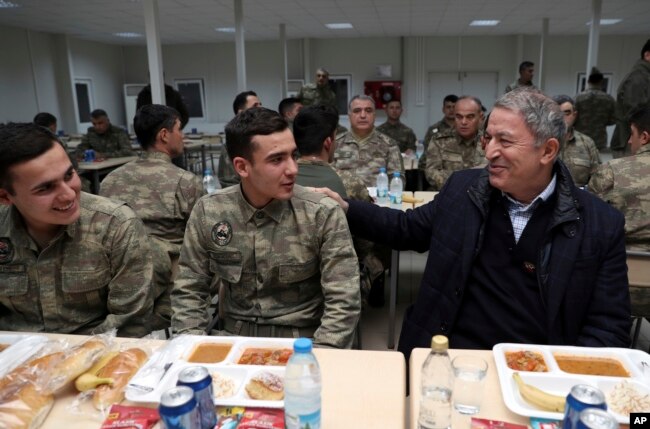 FILE - Hulusi Akar, Turkey's defense minister and former chief of staff, speaks with soldiers during a visit to Turkish troops stationed at the border with Syria, in Kilis, Turkey, Dec. 31, 2018. Russian and Turkish foreign and defense ministers met in Moscow two days earlier to discuss northern Syria as U.S. forces prepare to withdraw and Turkey threatens to launch a military operation against U.S.-backed Kurdish forces controlling nearly a third of the country.