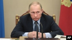 Russian President Vladimir Putin listens during a meeting at the Kremlin in Moscow, Russia, May 27, 2015. Putin said the United States is meddling in FIFA's affairs in an attempt to take the 2018 World Cup away from his country. 