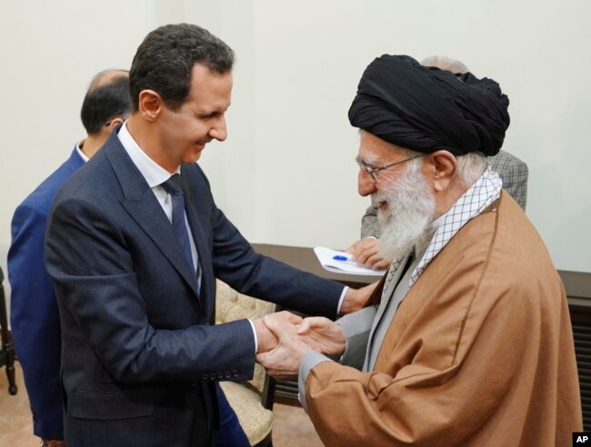 In this photo released by the Syrian official news agency SANA, Syrian President Bashar al-Assad, left, shakes hands with Iranian Supreme Leader Ayatollah Ali Khamenei, before their meeting in Tehran, Syria, Feb. 25, 2019.