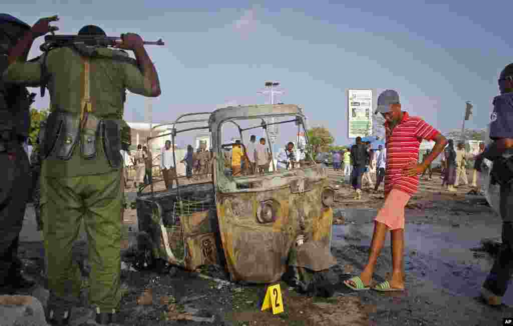 Des soldats somaliens se tiennent près de l&#39;épave d&#39;une moto sur les lieux de explosion en Somalie, le 25 mars 2018.