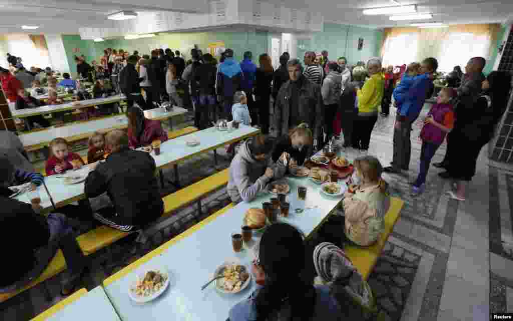 Refugees from the fighting in the eastern regions of Ukraine line up to receive food at the "Zharki" health resort outside the village of Rybnoye, east of Krasnoyarsk, Russia, Sept. 4, 2014.