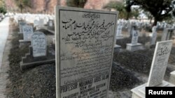 FILE - The word "Muslim" has been painted over by vigilantes, on the tombstone of Pakistani scientist Abdus Salam, a member of the Ahmadi community and Pakistan's only Nobel laureate, in the Ahmadi graveyard in the town of Rabwa, Dec. 9, 2013. A recent assassination victim in Pakistan was a relative of Salam.