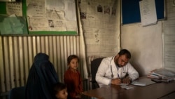 Dr. Gul Nazar writes a prescription for patients in the Mirbacha Kot hospital in Afghanistan, Oct. 25, 2021.