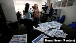 A journalist of pro-Kurdish Ozgur Gundem gives an interview to a German TV channel at their newsroom before a protest against the arrest of three prominent campaigners for press freedom, in front of the pro-Kurdish Ozgur Gundem newspaper in central Istanb