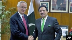 Newly appointed US ambassador to Pakistan Cameron Munter, left, shakes hand with Pakistani Interior Minister Rehman Malik prior to their meeting in Islamabad, Pakistan, Oct. 27, 2010 (file photo)