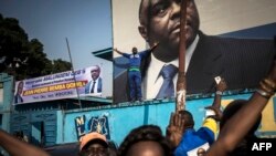 Les partisans de Jean-Pierre Bemba lèvent la main devant la photo de leur leader au siège du Mouvement de libération du Congo (MLC) à Kinshasa le 8 juin 2018 .