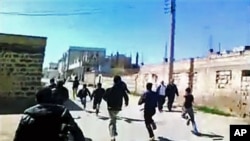 This image made from amateur video purports to show Syrian protesters running in Daraa, Syria, March 12, 2012.