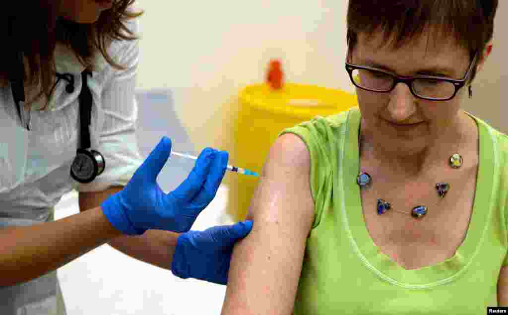 Volunteer Ruth Atkins receives an injection of the Ebola vaccine, at the Oxford Vaccine Group Centre for Clinical Vaccinology and Tropical Medicine (CCVTM) in Oxford, southern England, Sept. 17, 2014.