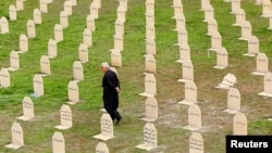 FILE - An Iraqi Kurd resident visits the cemetery for victims of the 1988 chemical attack in the Kurdish town of Halabja, near Sulaimaniya, 260 km (160 miles) northeast of Baghdad, March 16, 2014.