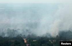 FILE - An aerial view of smoke rising from burnt trees during haze in Indonesia's Riau province, June 28, 2013.