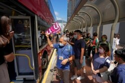 Penumpang mengantre untuk tur bus tidur di Hong Kong, Sabtu, 16 Oktober 2021. (Foto: AP/Kin Cheung)