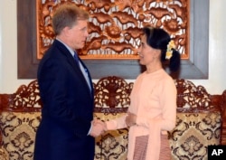 In this photo released by Myanmar Foreign Ministry, Myanmar's State Counselor Aung San Suu Kyi, right, shakes hands with U.S. State Department's Deputy Assistant Secretary for Southeast Asia Patrick Murphy, in Naypyitaw, Myanmar, Sept. 19, 2017.