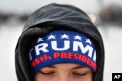 Raindrops gather on the head of Stephen Glinn as he waits on the National Mall in Washington, Jan. 20, 2017, before the presidential inauguration of Donald Trump.