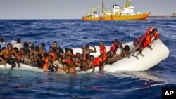 Migrants dans un canot pneumatique approchés par l'Aquarius de SOS Meditrranée au large des côtes de l'île italienne de Lampedusa, le 17 avril 2016.