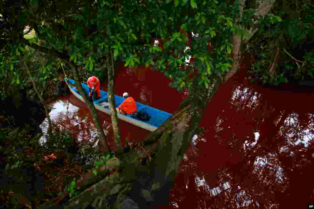 Workers from a company outsourced by Mexico&#39;s state-owned oil company Pemex try to remove fuel after a pipeline spill of premium gasoline contaminated the Hondo River near the town of Tierra Blanca, Aug. 31, 2014.