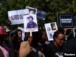 FILE - Demonstrators hold a march and rally to protest the fatal police shooting of Ugandan immigrant Alfred Olango in El Cajon, California, Oct. 1, 2016.