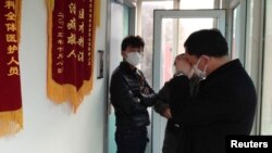 Friends of human right activist Cao Shunli stand in front of an intensive care unit where Cao was hospitalized at a hospital in Beijing on March 1, 2014.