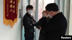 Friends of human right activist Cao Shunli stand in front of an intensive care unit where Cao is hospitalized as they are not allowed to go inside. Beijing, China, Mar. 1, 2014.