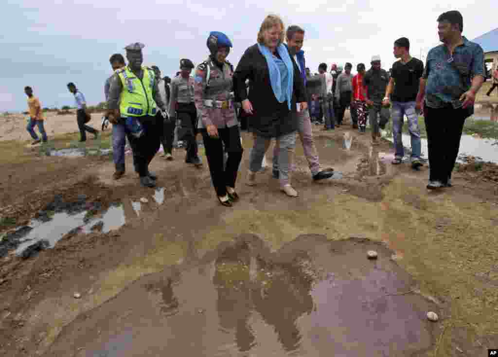 U.S. Assistant Secretary of State for Population, Refugees, and Migration Anne C. Richard is escorted by police officers and other officials during her visit to a temporary shelter for Rohingya and Bangladeshi migrants in Kuala Cangkoi, Aceh province, Indonesia, June 2, 2015.
