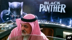 A visitor checks out a Lexus, similar to one used in the "Black Panther" film, that is on display outside an invitation-only screening, at the King Abdullah Financial District Theater, in Riyadh, Saudi Arabia, April 18, 2018. Saudi Arabia held a private screening of the Hollywood blockbuster "Black Panther" Wednesday, to herald the launch of movie theaters that are set to open to the public next month. 