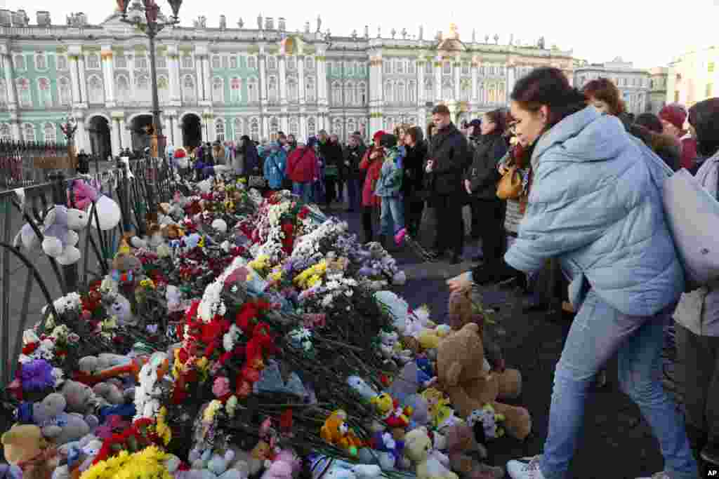 People mourn as they lay flowers in memory of the plane crash victims at Dvortsovaya (Palace) Square in St. Petersburg, Russia.