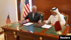 Qatar's foreign minister Sheikh Mohammed bin Abdulrahman al-Thani (R) and U.S. Secretary of State Rex Tillerson sign a memorandum of understanding in Doha, Qatar, July 11, 2017.